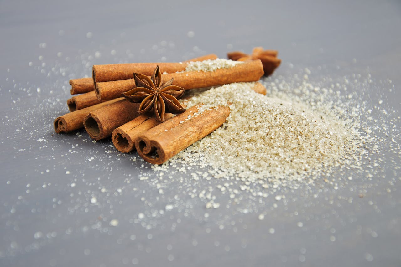 Close-up of cinnamon sticks and star anise on a sugar pile, perfect for winter recipes.